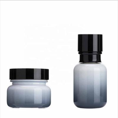 Juego de botellas de vidrio de color degradado gris negro para el cuidado de la piel
